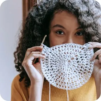 Een tevreden persoon dat een haakwerkje vasthoudt