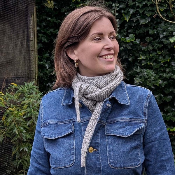 Een vrouw die een grijze Rina sjaal draagt